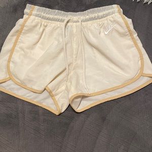 small cream nike athletic shorts with a tan Lining netting inside